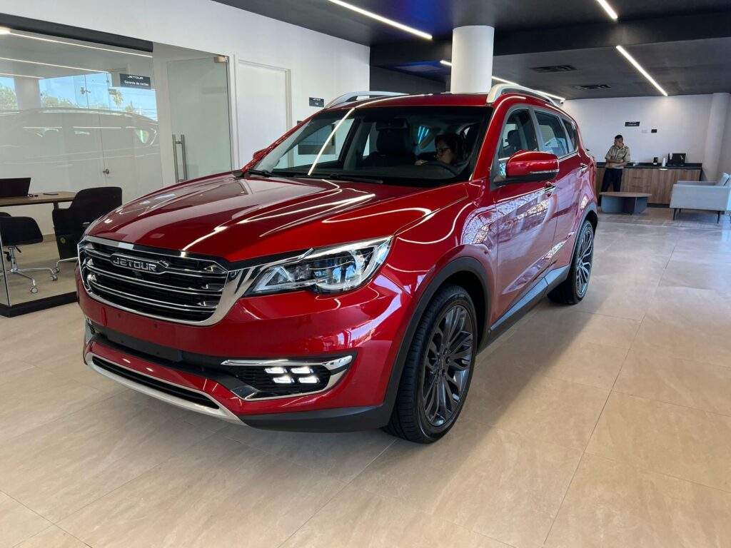 SUV Jetour X70 en color rojo exhibido en el showroom, destacando su elegante diseño frontal y lateral